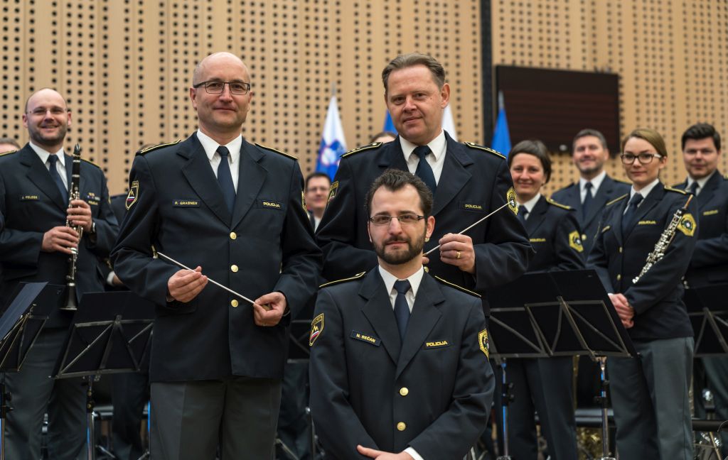 slika orkestra, spredaj vodja Policijskega orkestra, dirigent in asistent dirigenta
