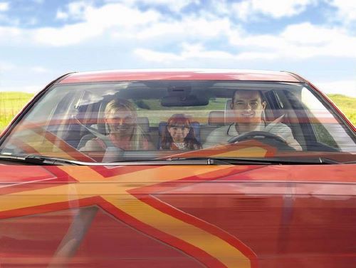 picture of a family in a vehicle in front of a railway barrier