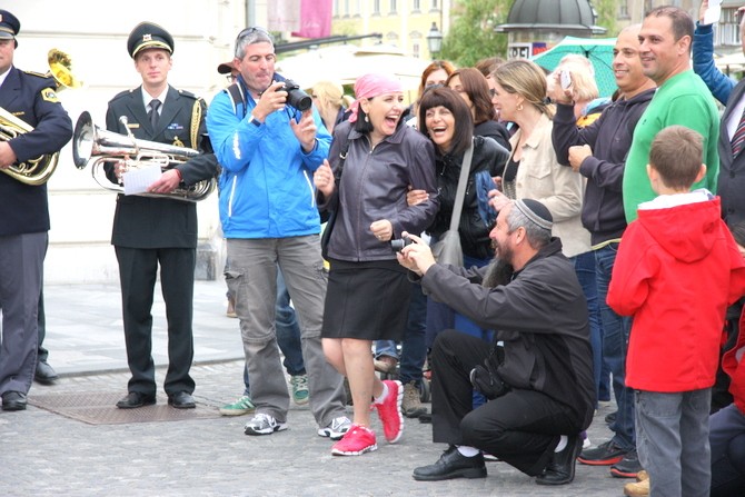 slika skupine mimoidočih, ki z veseljem spremljajo nastop obeh orkestrov, Ljubljana, 2013