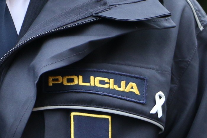 slika dela policijske uniforme z belo pentljo