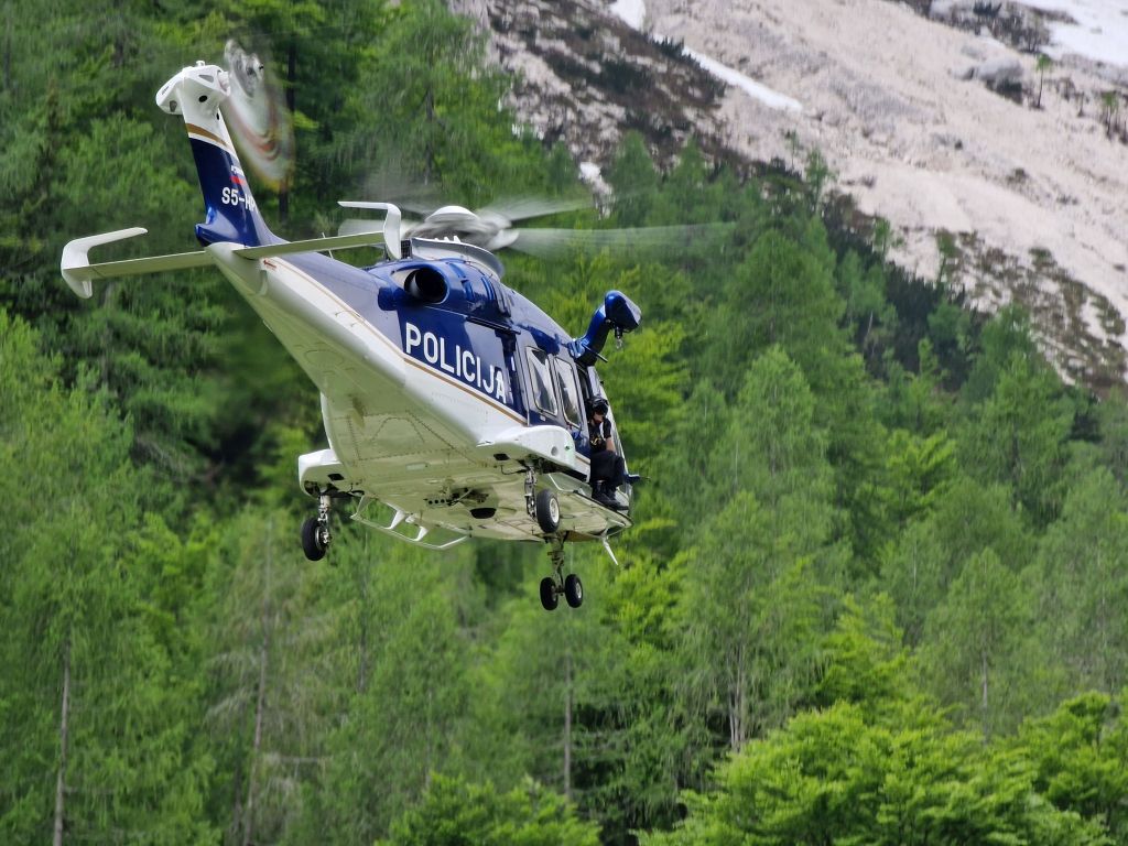 Policijski helikopter leti nad gorskim pobočjem