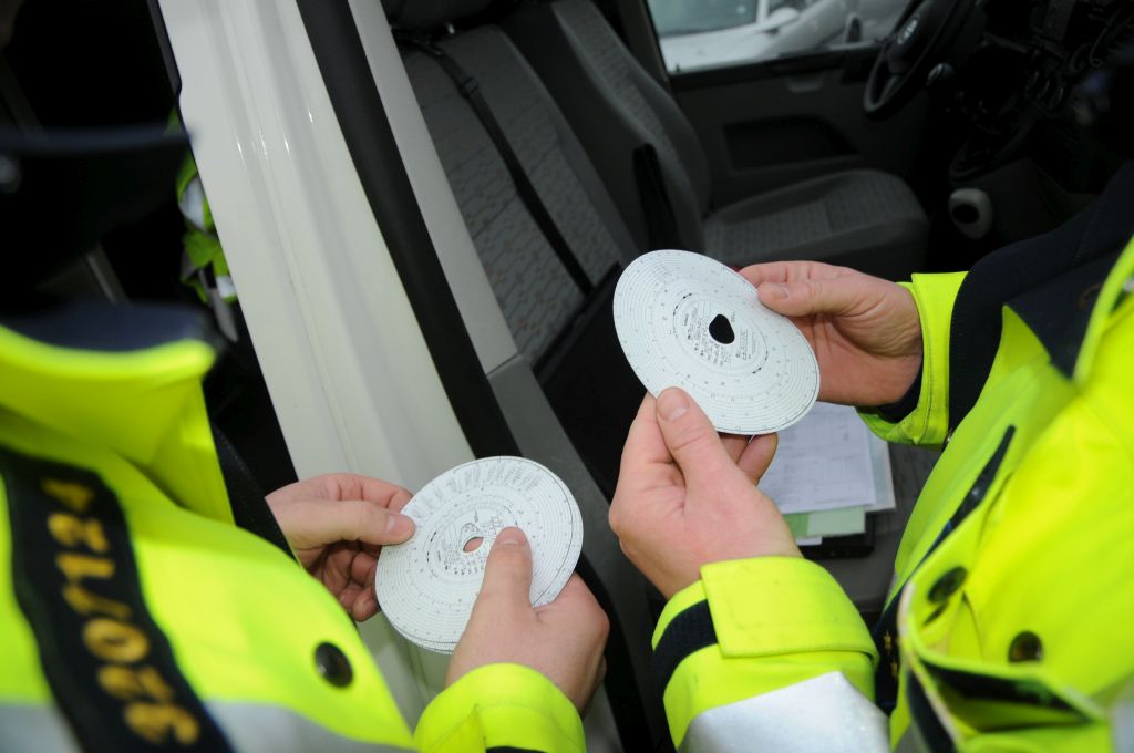 Prometna policista med nadzorom tovornega prometa pregledujeta izpise iz tahografov