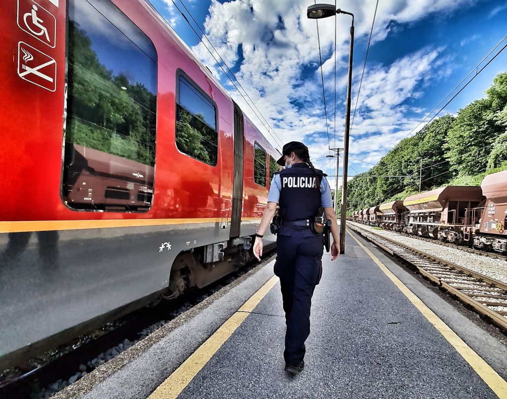 Policistka stopa ob vlaku