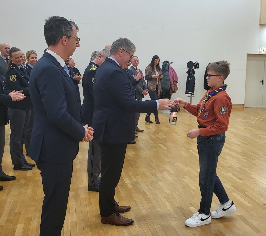Predstavnik skavtov predaja luč ministru