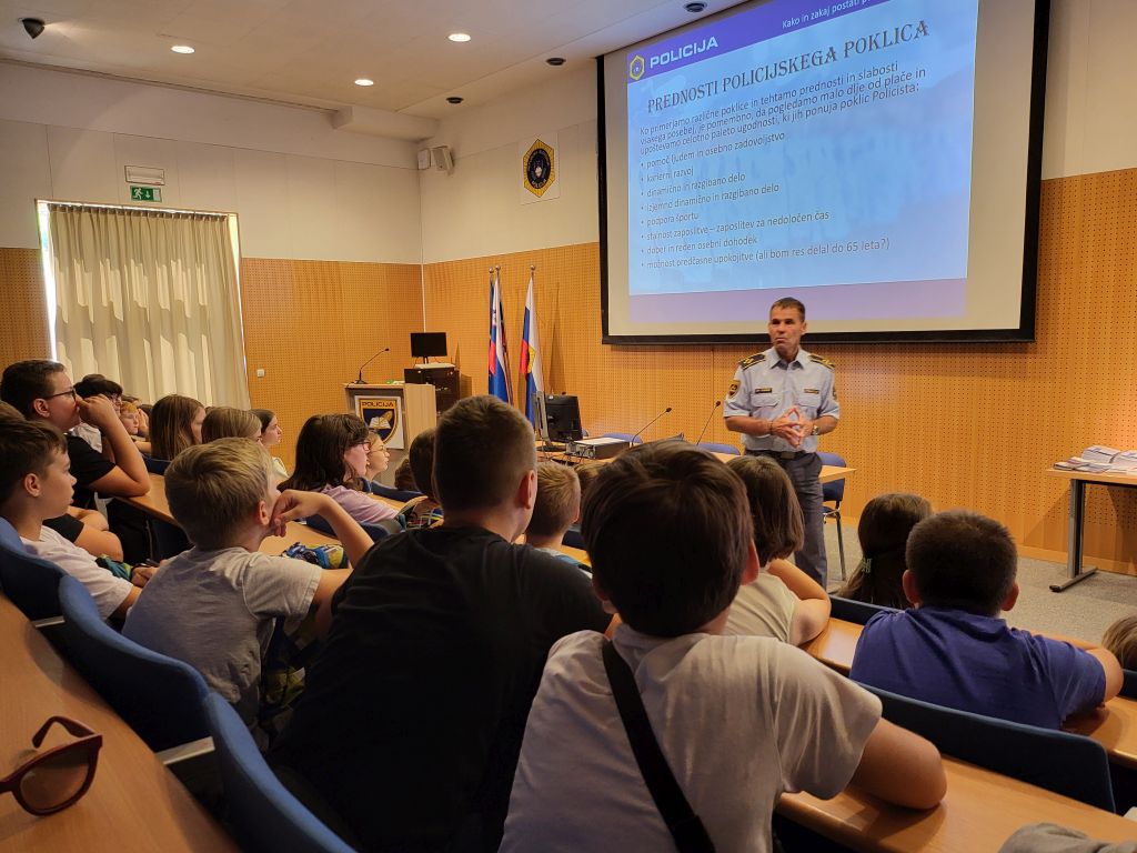 Otroci v predavalnici poslušajo predavanje o policijskem poklicu.