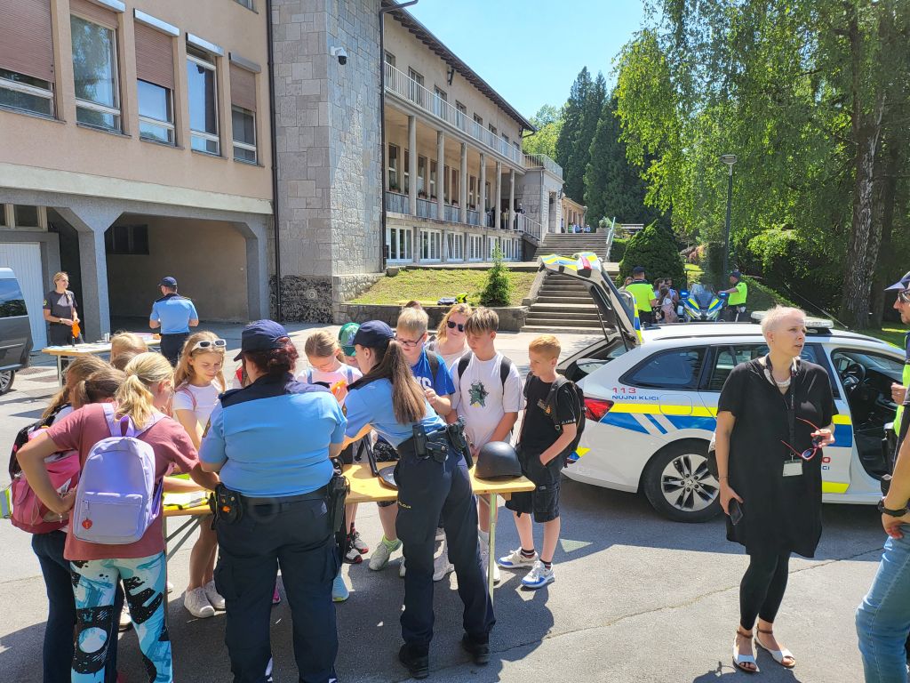 2 splošni policistki otrokom kažeta policijsko opremo.