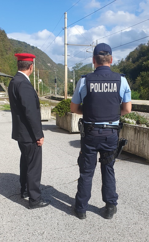 Policist in strojevodja stojita ob progi