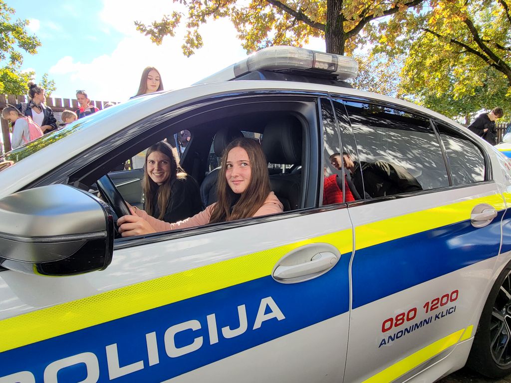 Nasmejani dekleti - obiskovalki v policijskem vozilu, ena za volanom, druga kot sopotnica