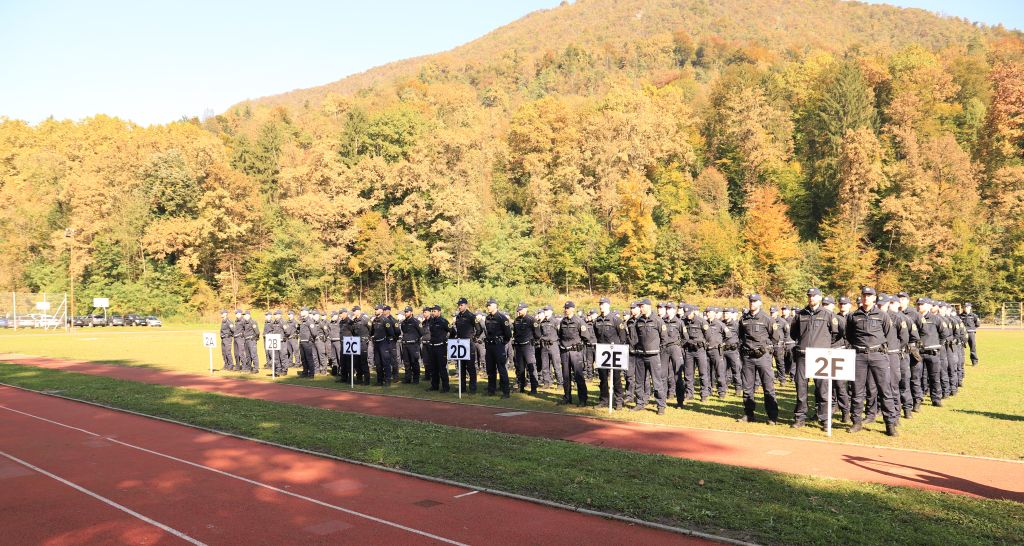 Na sliki je zbor vseh razredov policistov, ki bodo zaprisegli. Stojijo v kolonah in vrstah na stadionu.