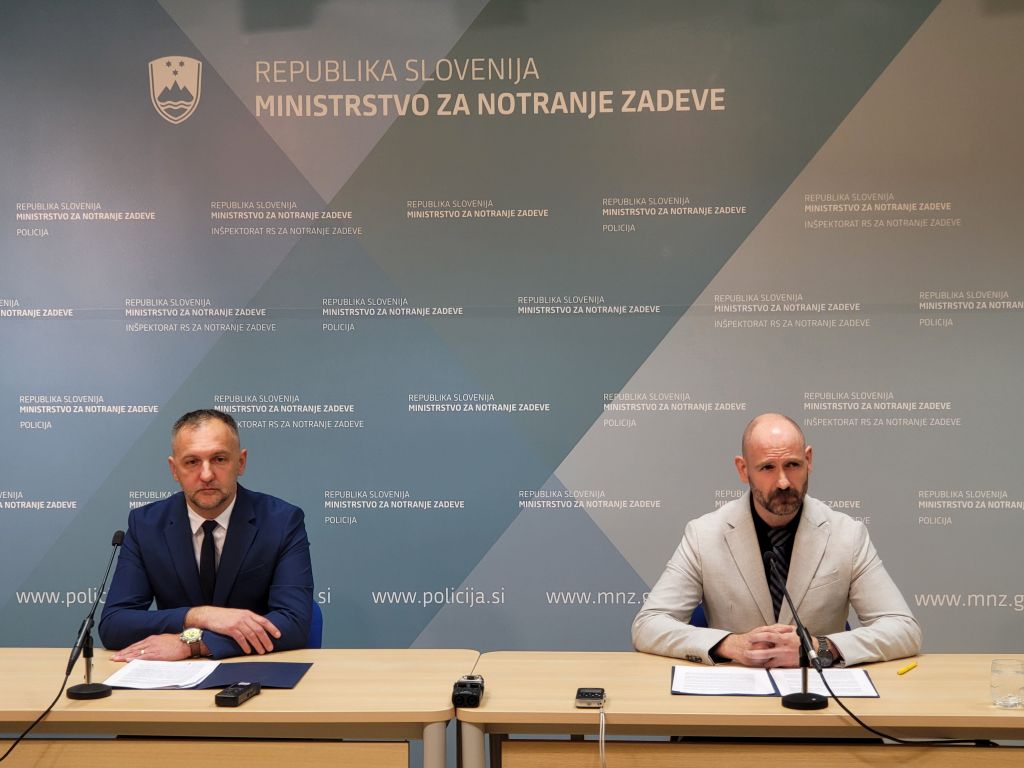 Predstavnika policije Podbelšek in Tekavec na novinarski konferenci sedita za mizo pred mikrofonoma