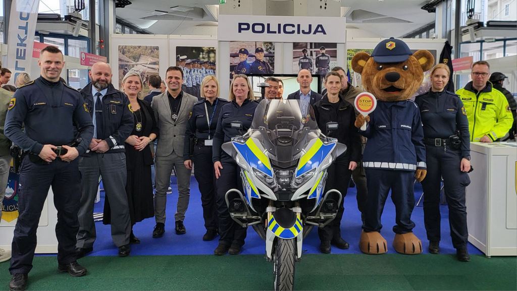 Sodelujoči predstavniki Policije, skupinska slika na razstavnem prostoru ob policijskem motorju