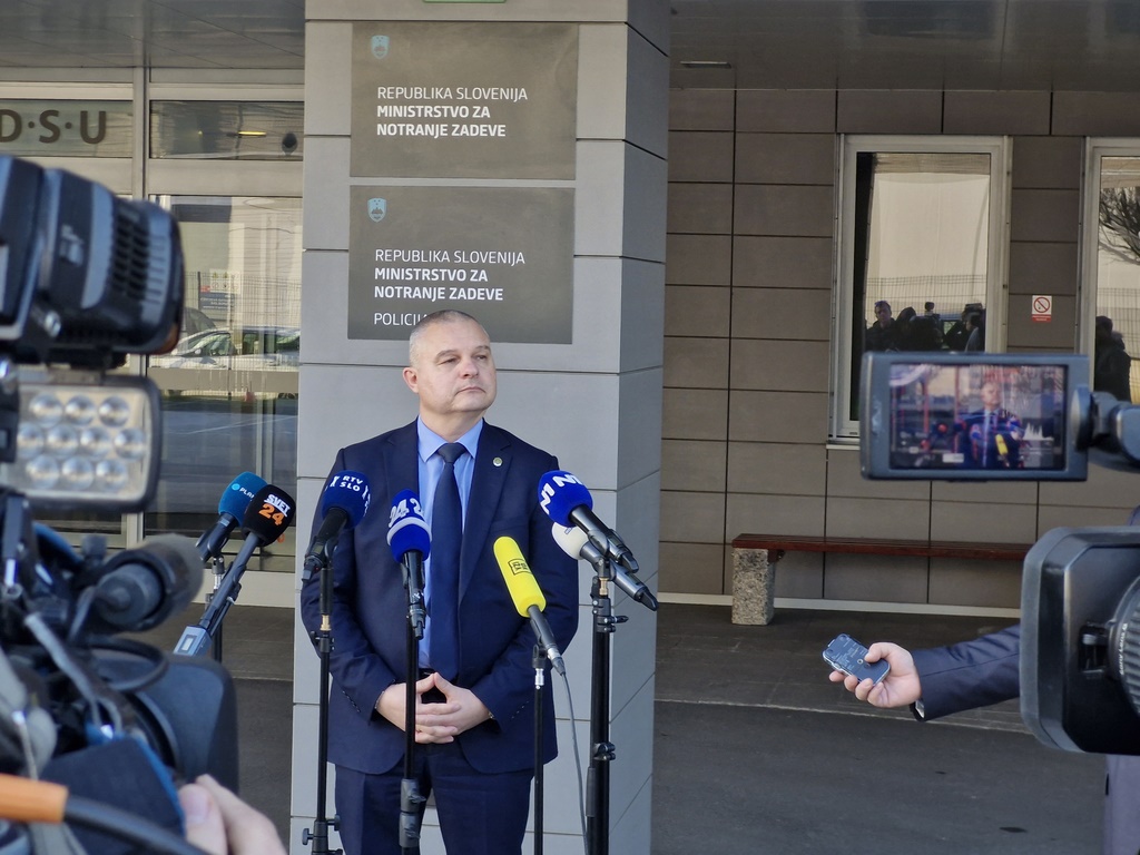 Darko Muženič, direktor NPU, stoji pred mikrofoni in kamerami, daje izjavo.