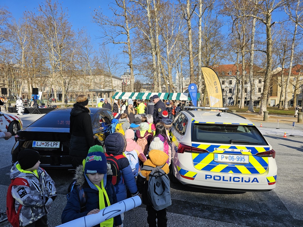 Skupina otrok, zbranih okoli policijskega vozila, ki je parkirano na Kongresnem trgu