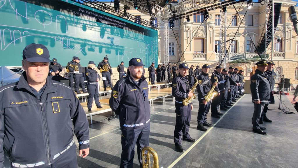Člani Policijskega orkestra stojijo na odru.