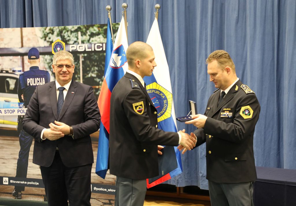 Med podelitvijo. V. d. generalnega direktorja policije čestita policistu Žanu Katoni, poleg stoji minister
