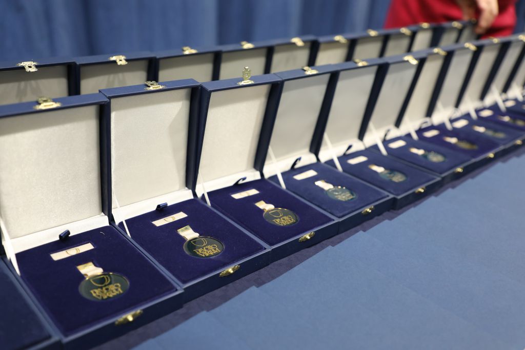 Škatlice z medaljami, razporejene v vrsti na mizi, čakajo na podelitev