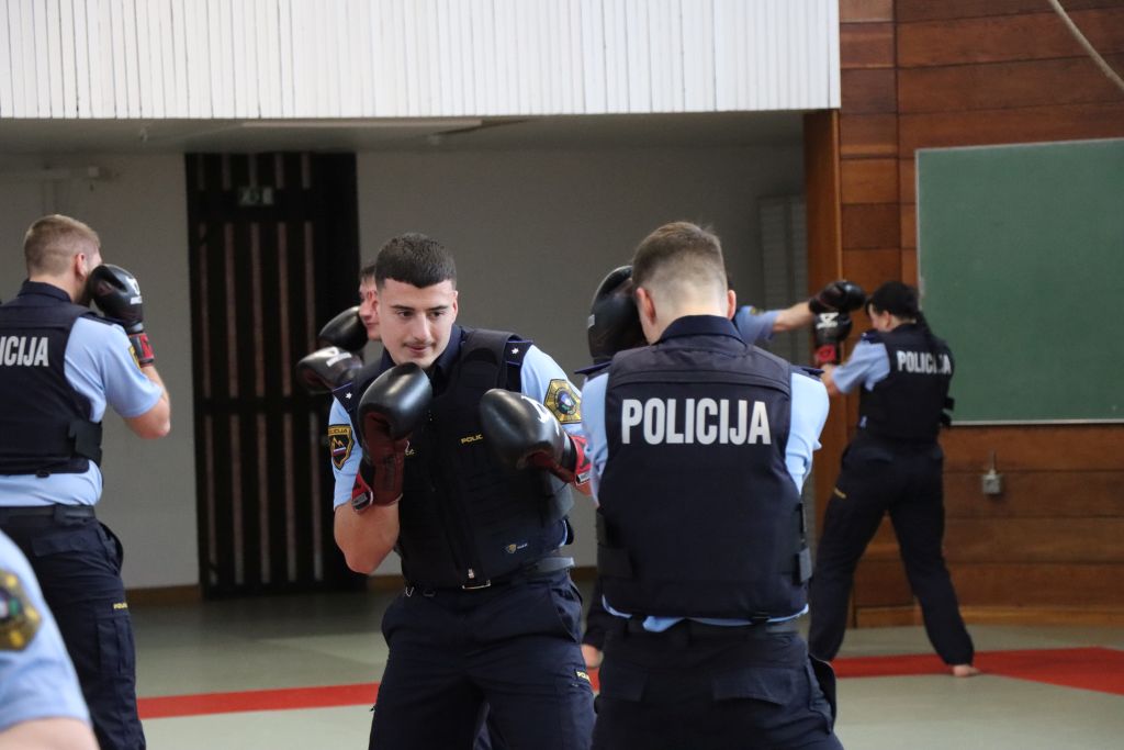 Kandidati za policiste med prikazom borilnih veščin na telovadnih blazinah