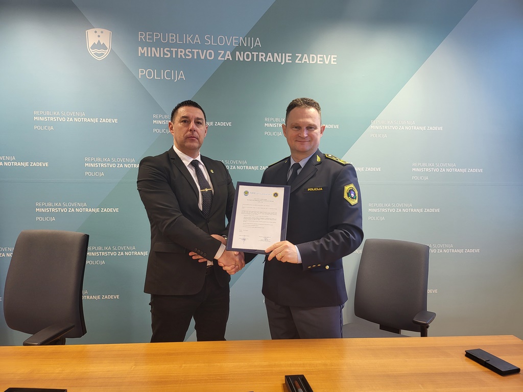 V. d. generalnega direktorja policije Damjan Petrič, mag., in predsednik Društva kriminalistov Slovenije Damjan Apollonio, mag., se rokujeta.