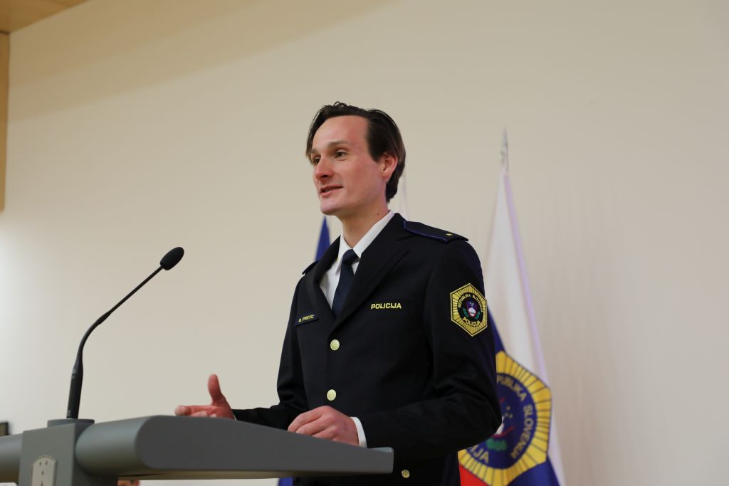 Domen Prevc med nagovorom, stoji za govornico, pred njim je mikrofon.