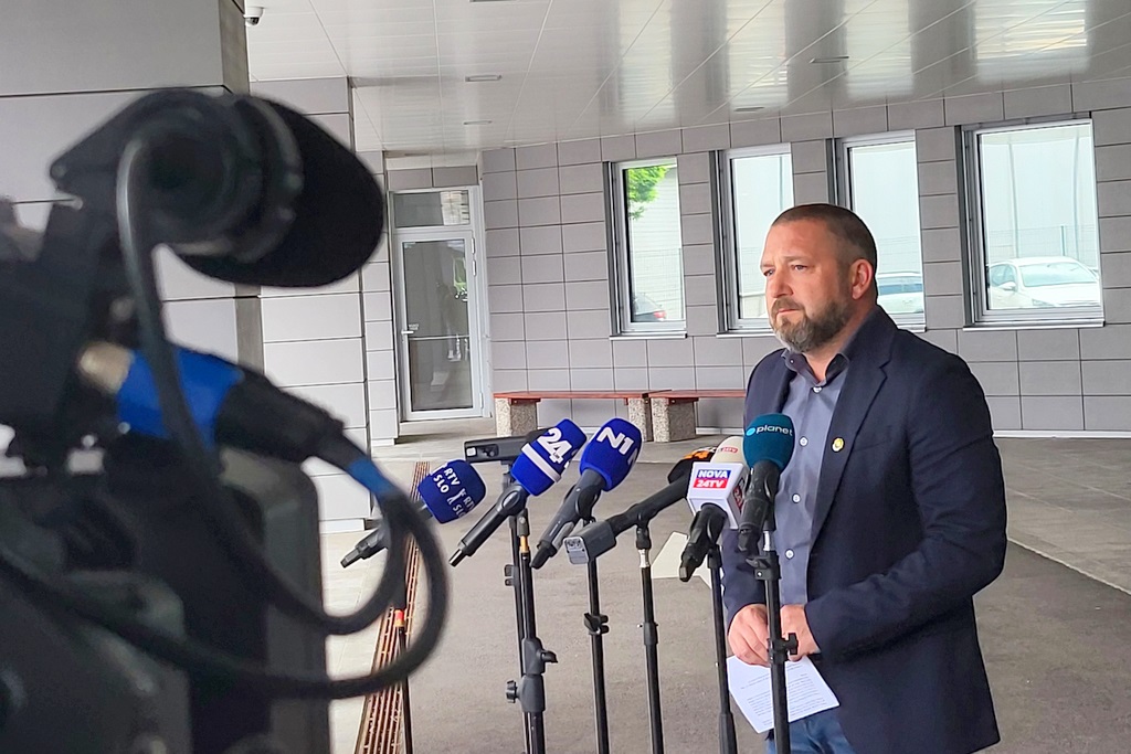 Primož Ogrinc podaja izjavo, v ozadju stavba