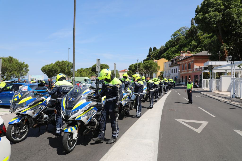 Piran. Policisti motoristi stojijo ob motorjih, parkiranih v vrsti, in si pripenjajo čelade. Foto Andraž Šegš