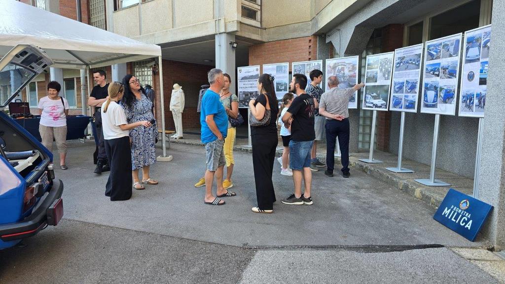 Obiskovalci si ogledujejo fotografsko razstavo in druge predmete