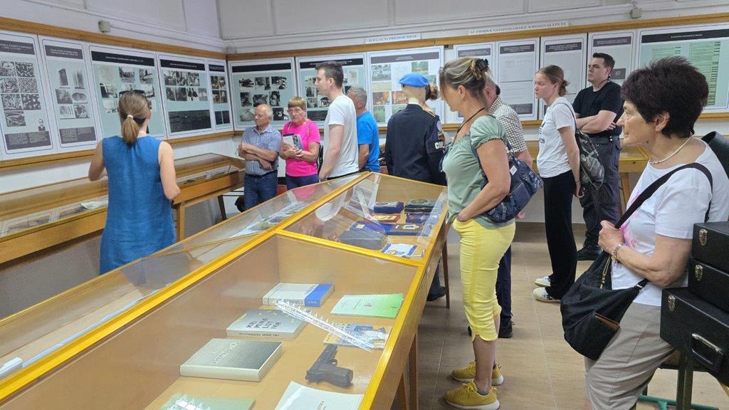 Obiskovalci si ogledujejo razstavljene muzejske predmete