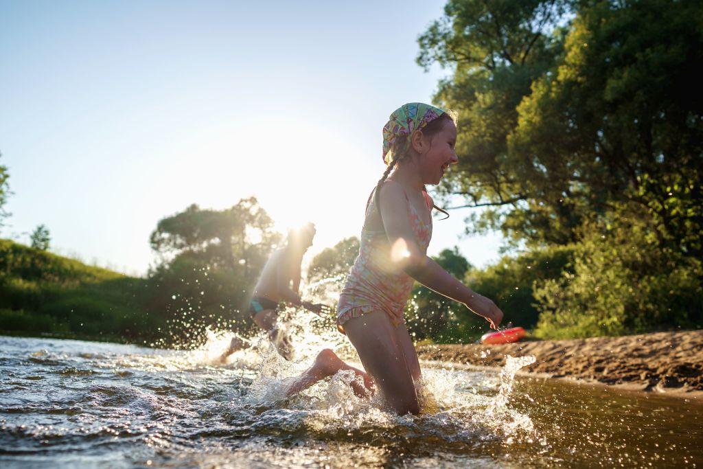 Razigrana otroka tečeta iz vode proti plaži