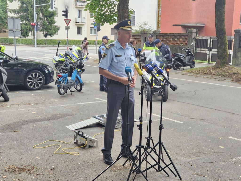 Mag. Kapun med izjavo za medije na parkirišču, stoji pred mikrofoni.