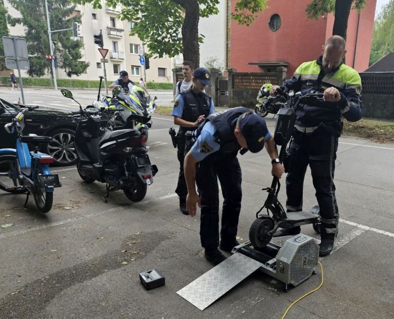 Policista med prikazom delovanja naprave za ugotavljanje največje hitrosti, ki jo lahko doseže e-skiro.