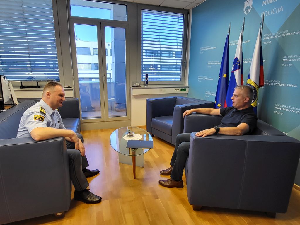 Petrič in Jušić v sproščenem pogovoru, sedita v pisarni generalnega direktorja policije.