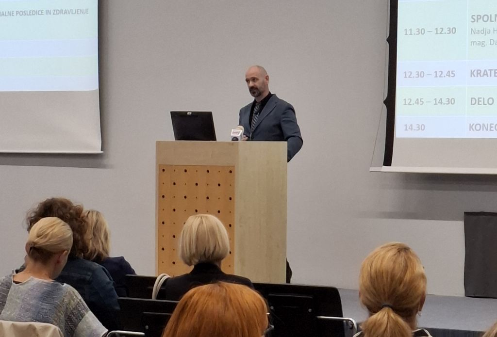 Robert Tekavec med nagovorom, stoji za govornico na odru.