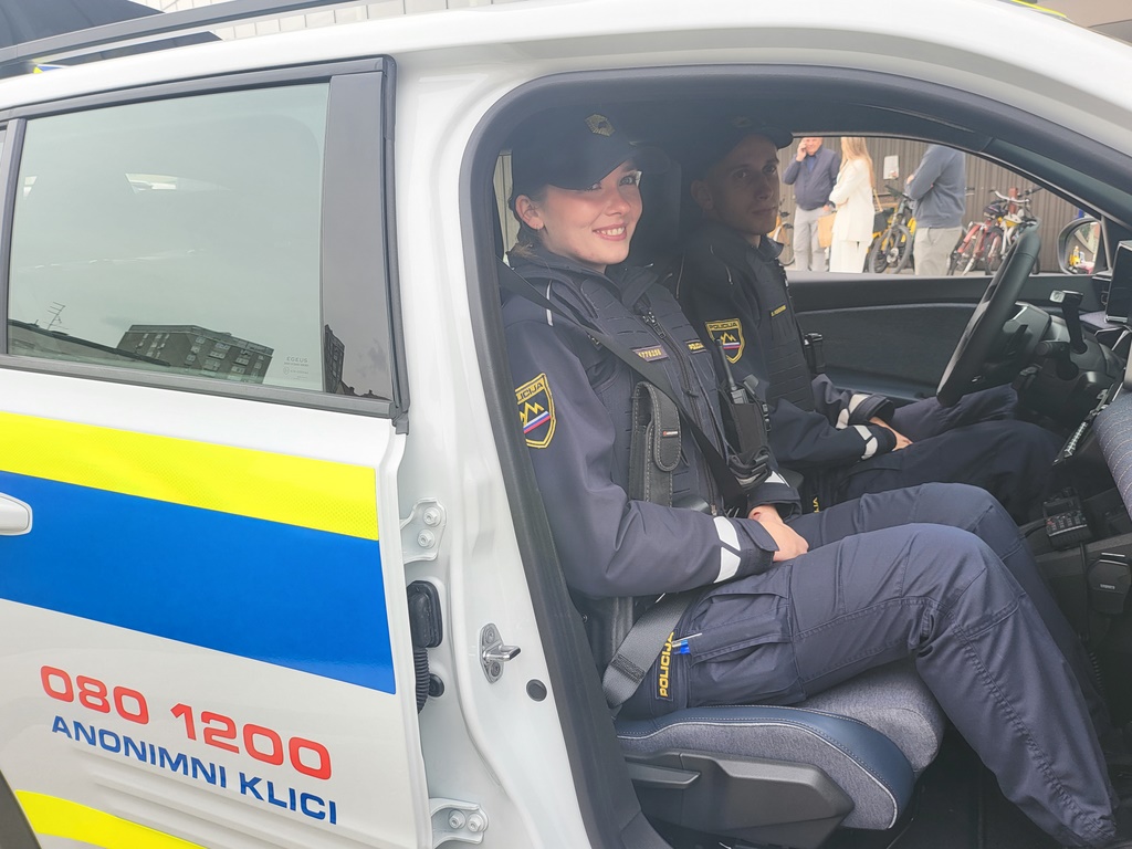 Policistka in policist sedita v vozilu