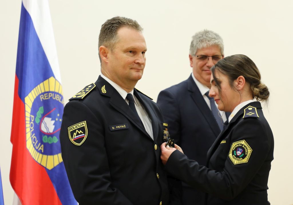 Policistka Petriču pripenja znak generalnega direktorja policije.