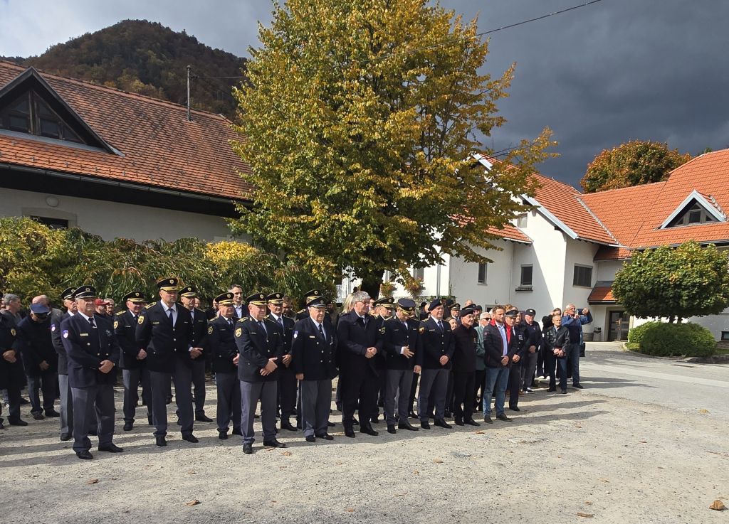 Udeleženci slovesnosti stojijo pred stavbo v Gotenici