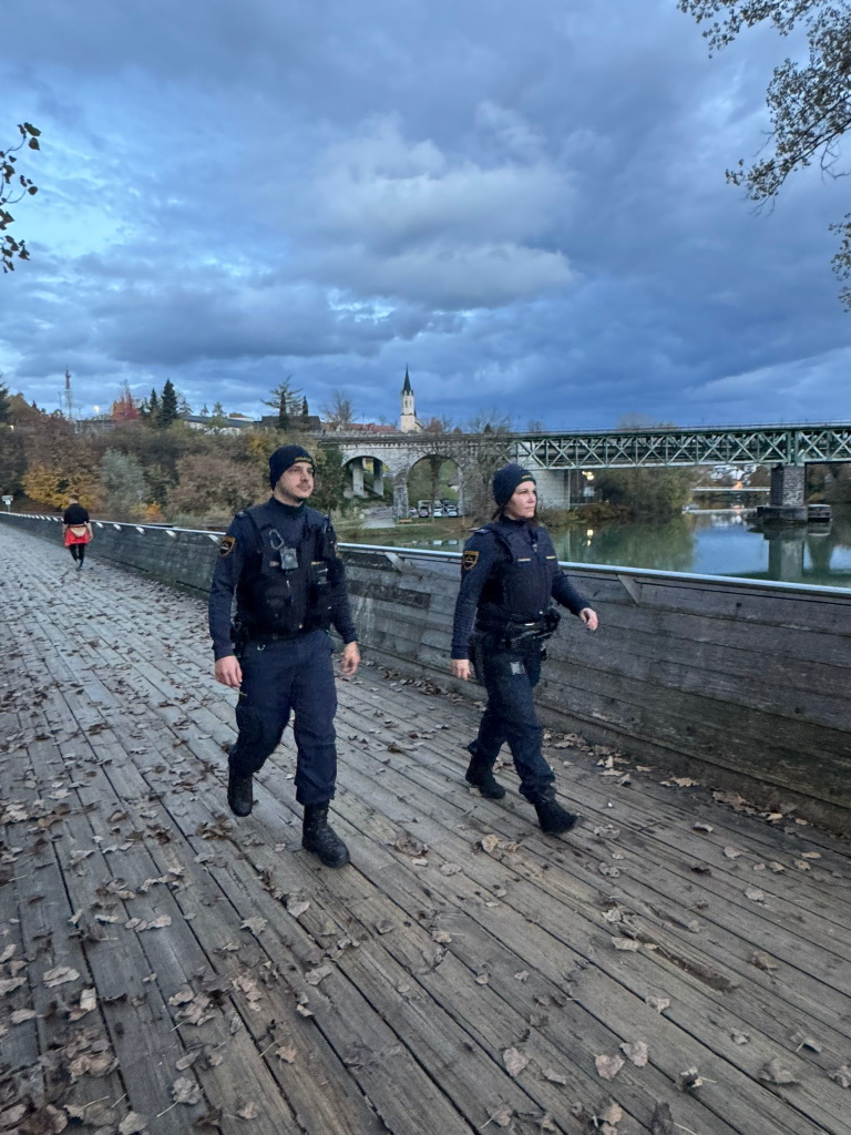 Policist in policistka patruljirata po mostu.