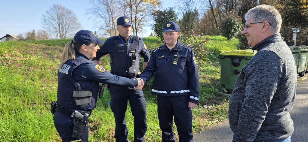 Generalni direktor se rokuje s policistko, zraven minister in policist