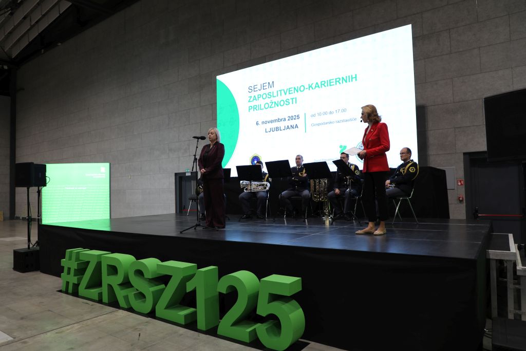 Direktorica ZRSZ med nagovorom, za njo sedi kvintet Policijskega orkestra.