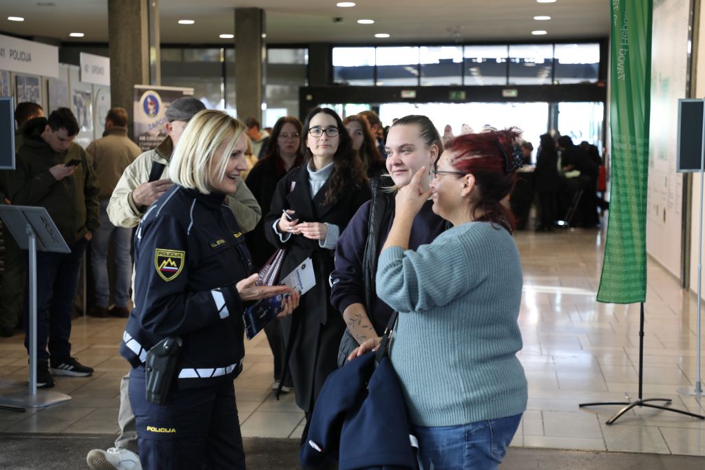 Policistka se pogovarja z dvema obiskovalkama.