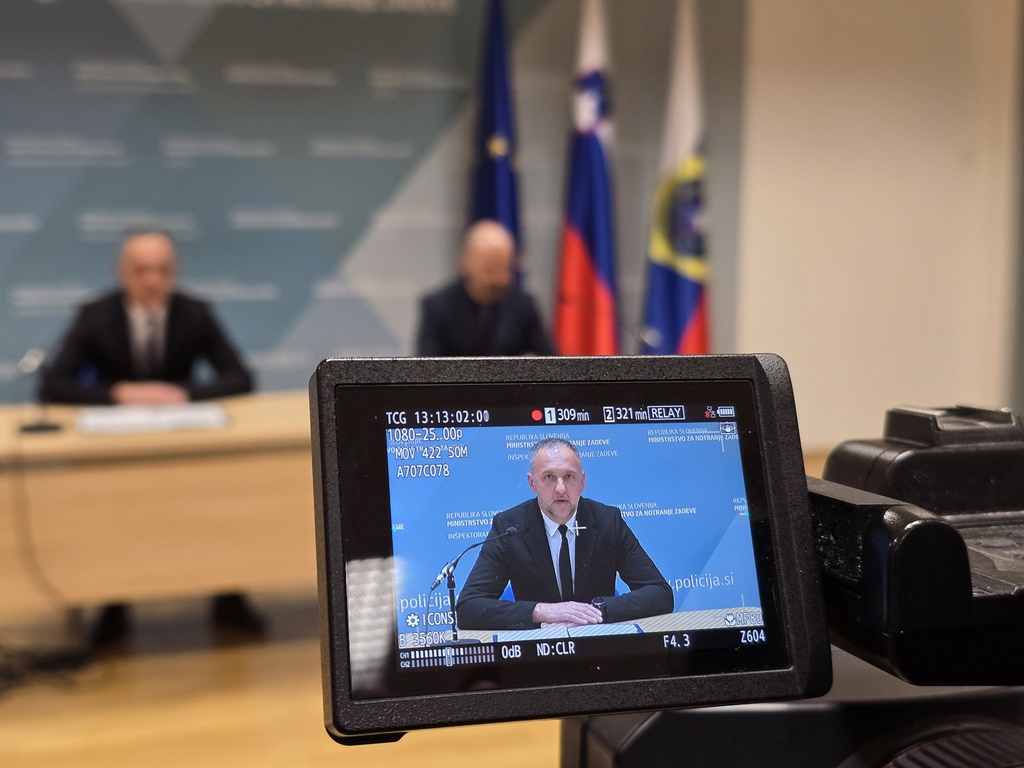 Kamera, v ozadju sta govorca