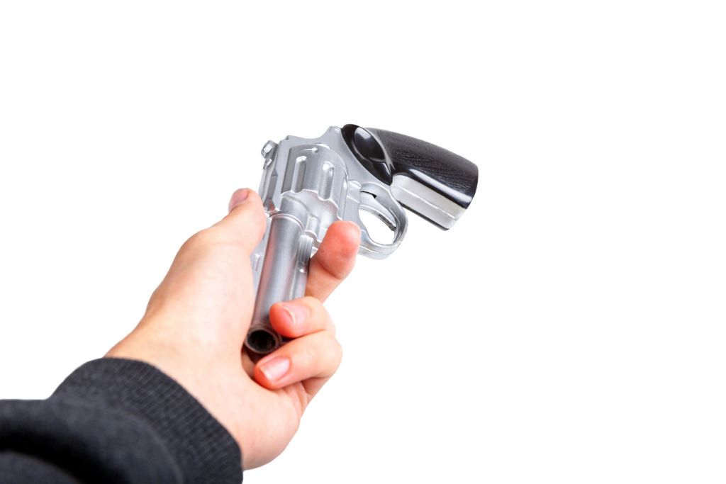 Nekdo izroča pištolo nekomu (viden del roke z orožjem)