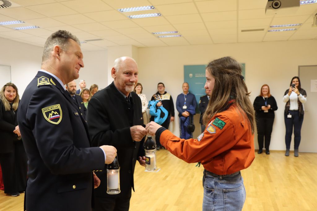 Petrič in Zlobko iz rok skavtinje sprejemate lučko miru