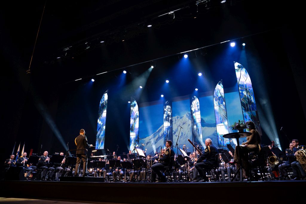 Policijski orkester med nastopom, v ozadju projekcija zasneženih gora