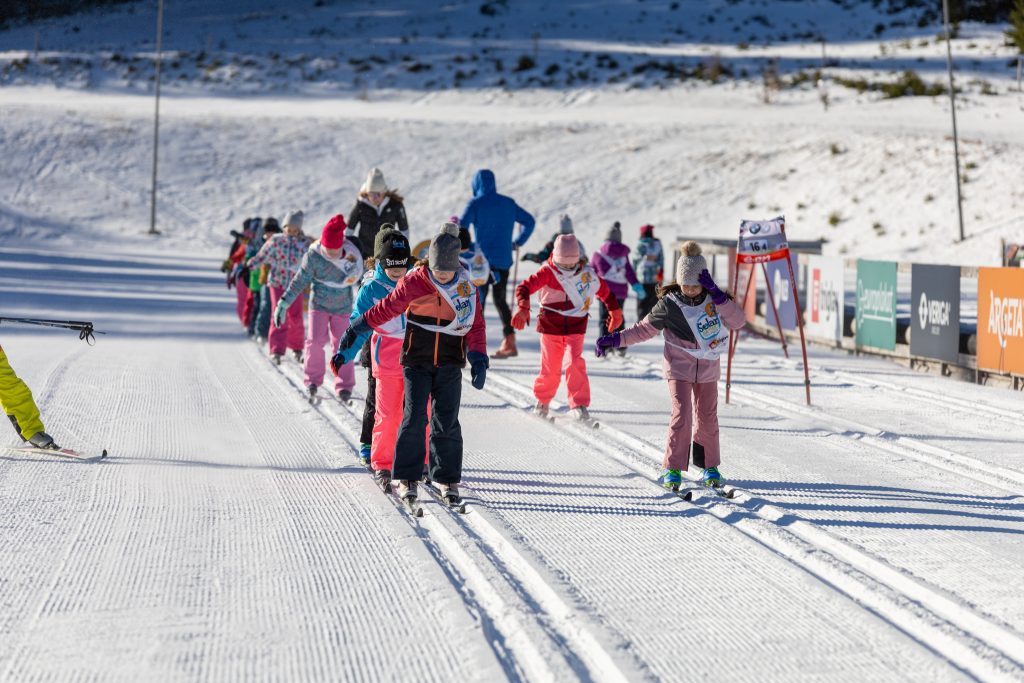 Skupina otrok med tekom na smučeh