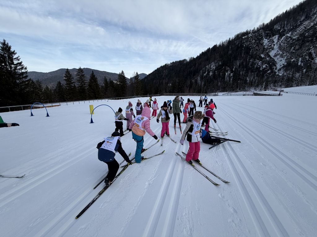 Skupina otrok s tekaškimi smučkami na snegu