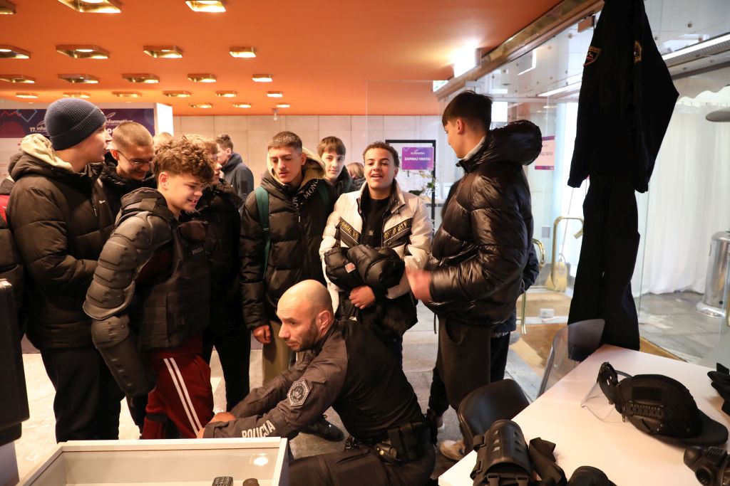 A member of the Riot Police Unit is showing his police equipment to a group of visitors