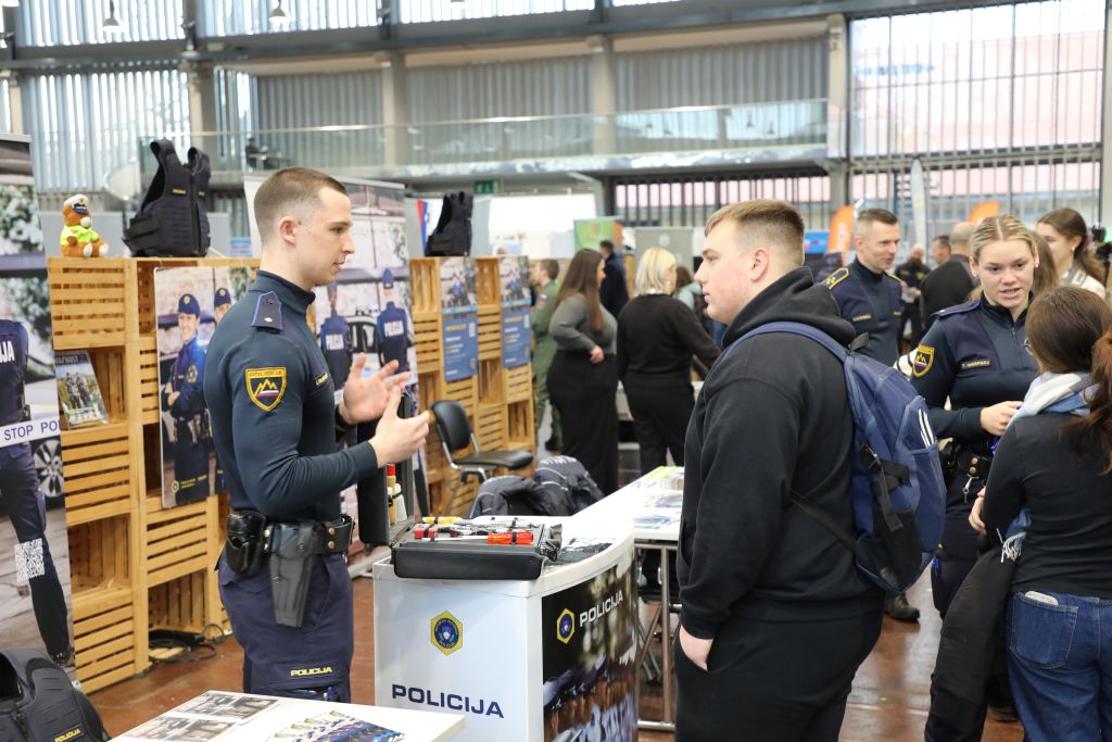 A young police officer talking to a visitor at the fair
