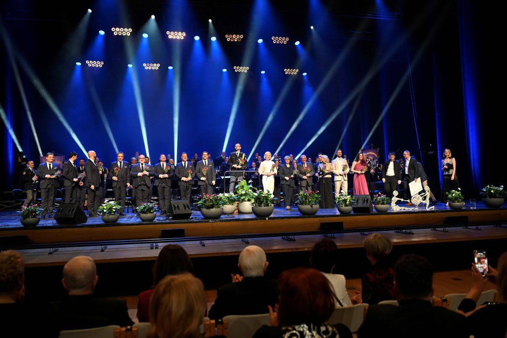 Skupinska slika izvajalcev in visokih gostov na odru ob zaključku koncerta