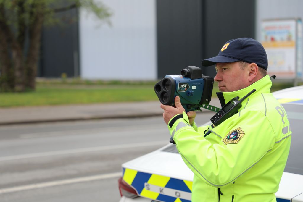 Prometni policist meri hitrost z radarjem.