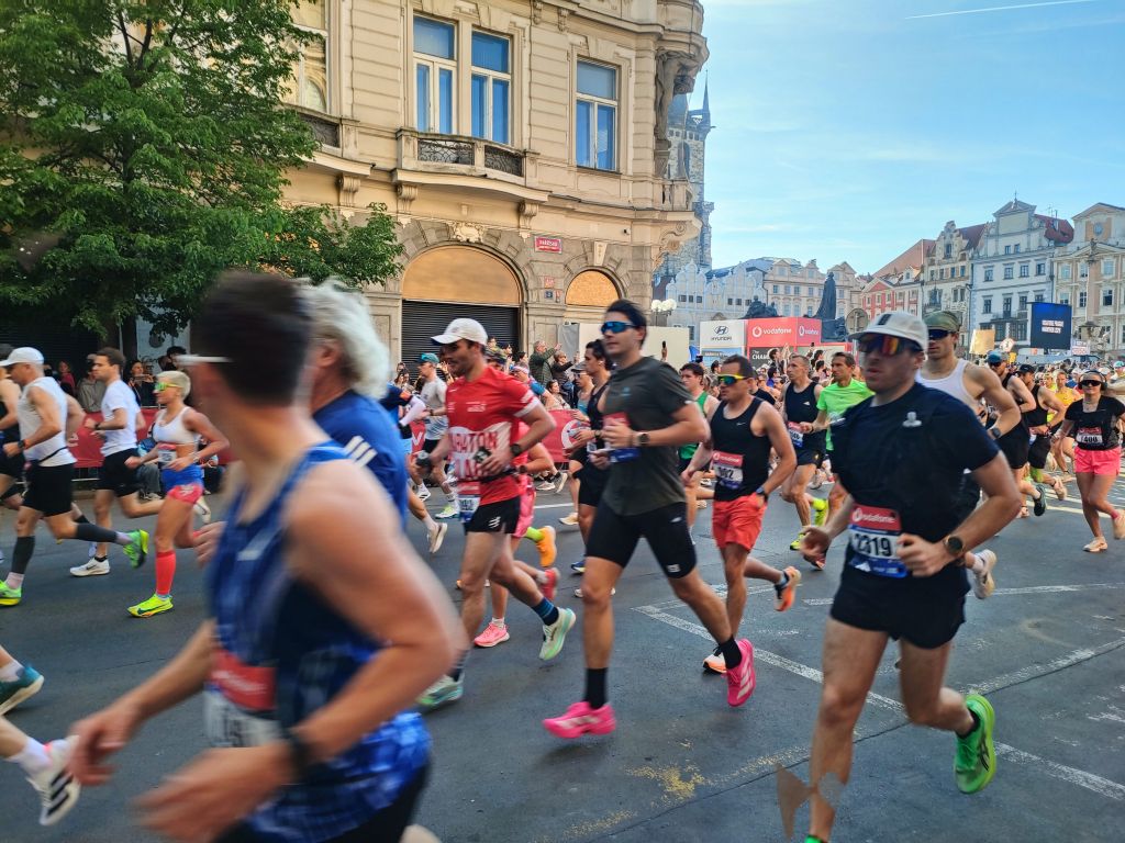 Množica tekačev na maratonu, tečejo po mestu.